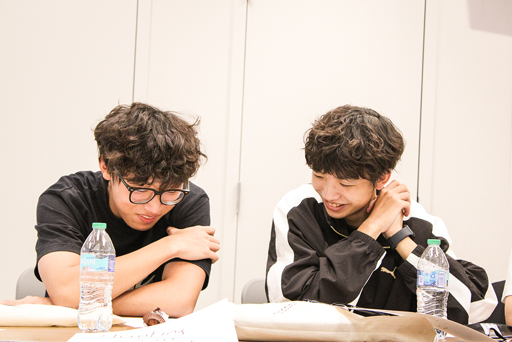 Two students reading together and smiling at Conversation Partners meeting.