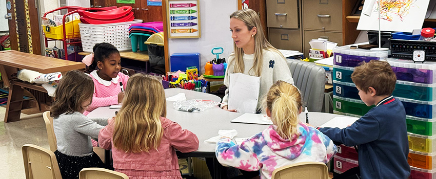 kilby kids learning with a teacher at a table