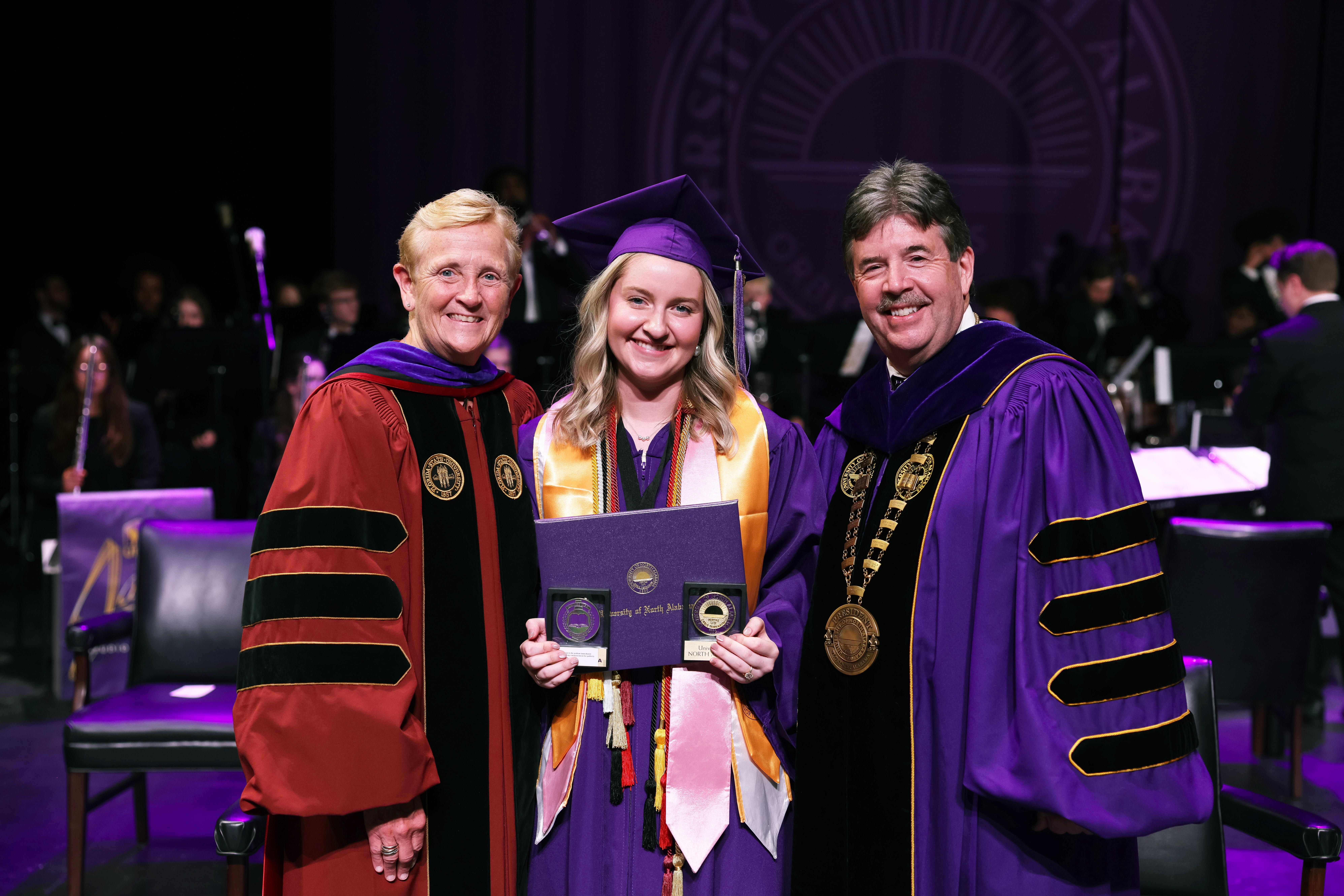 Madison Hogan, center, received the Keller Key and the Turris Fidelis Key as part of UNA's spring commencement. She is flanked by UNA President Dr. Ken Kitts on her left and Vice President of Student Affairs, Dr. K.C. White, on her right.
